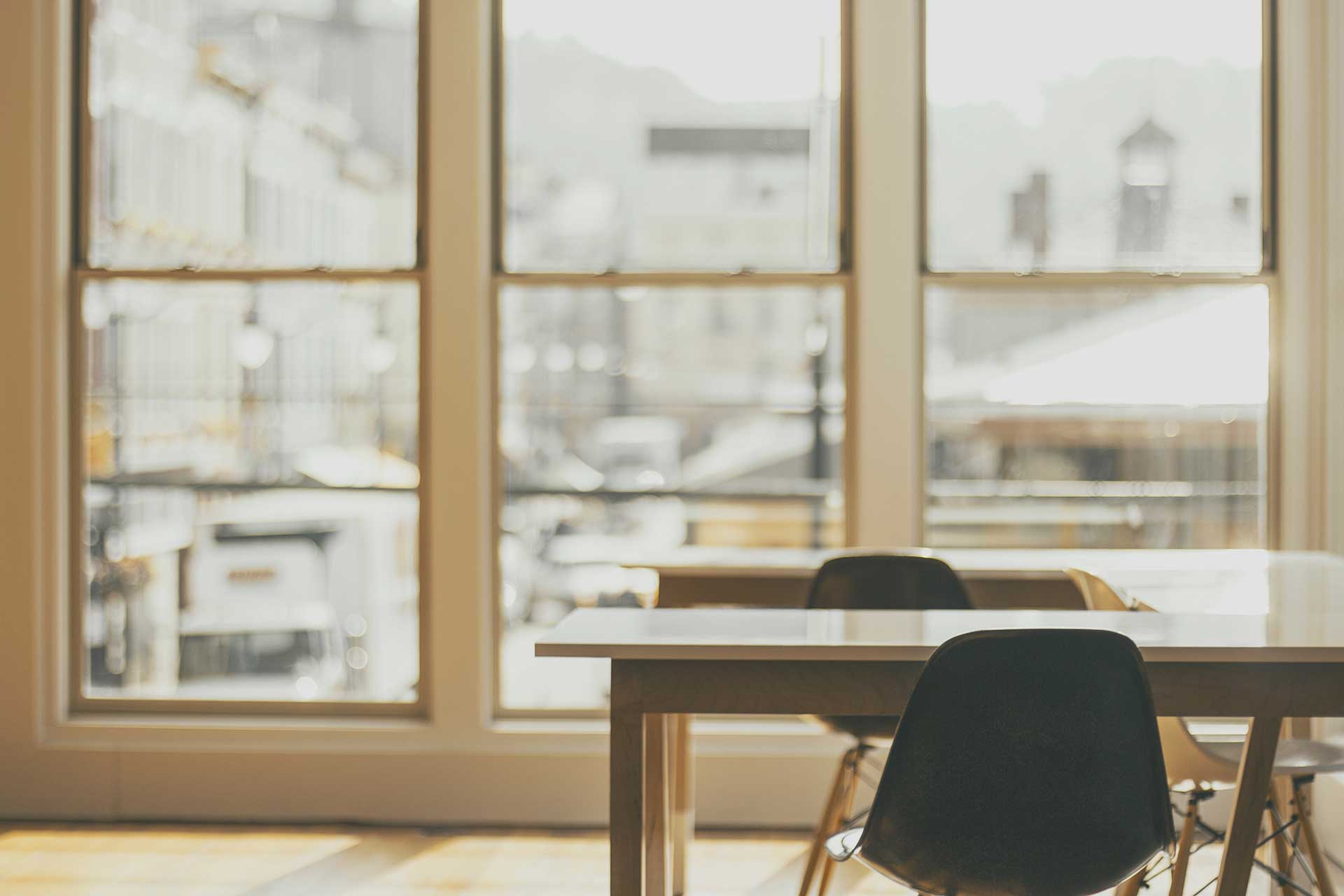 Filtered office view with a table and chairs looking out onto a street