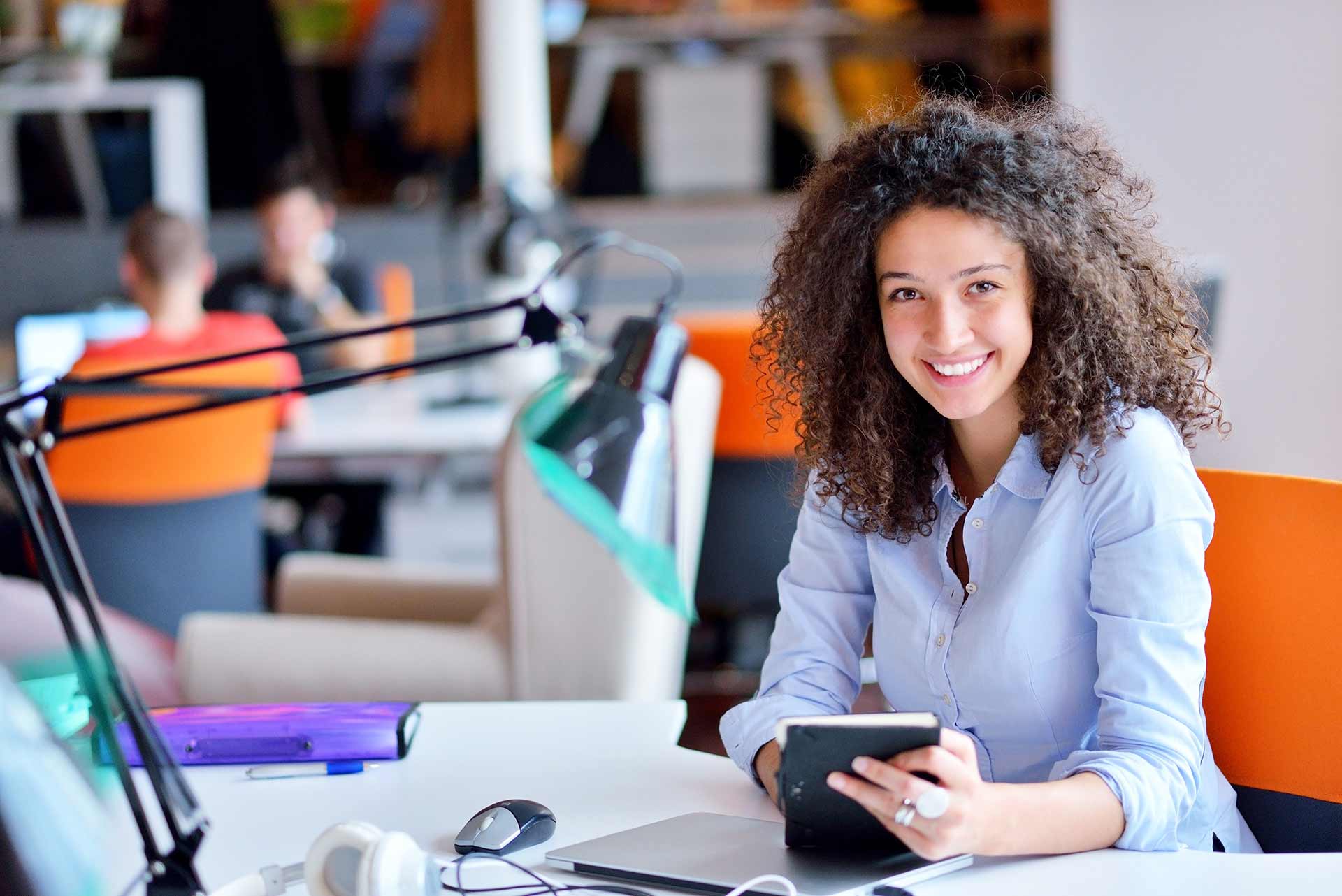 Women sitting on desk smiling