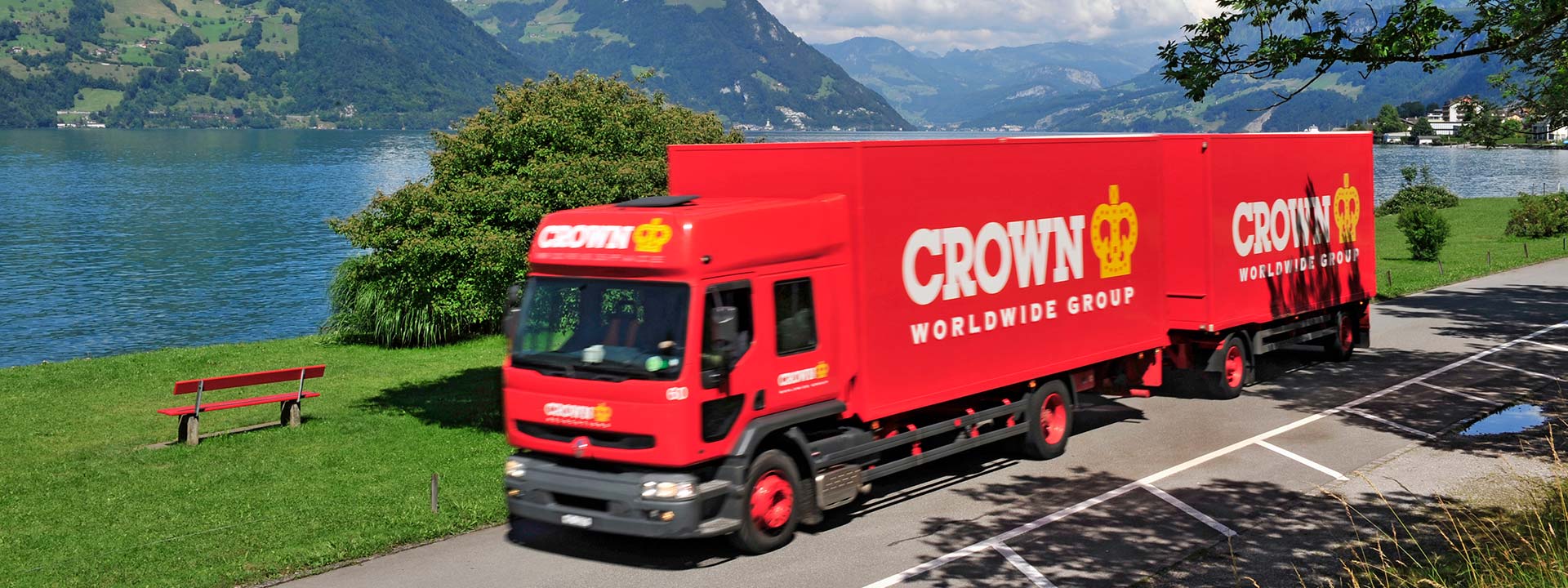 Red Crown Worldwide Group lorries in front of lake and mountains